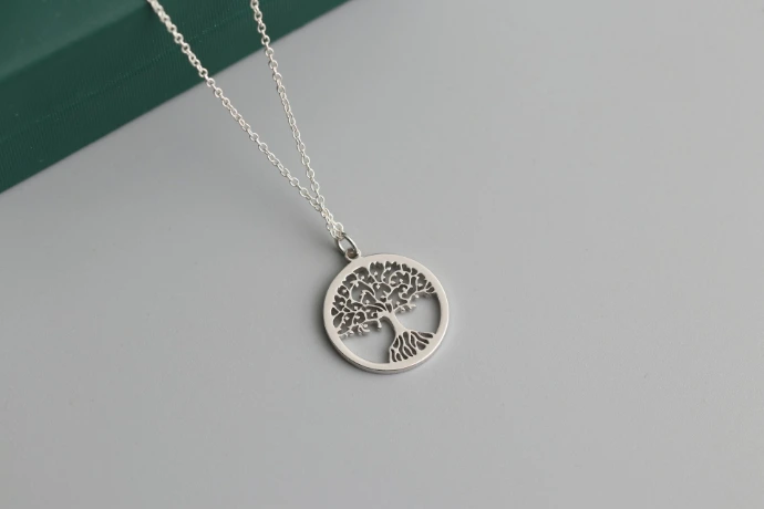 a silver tree of life pendant on a chain
